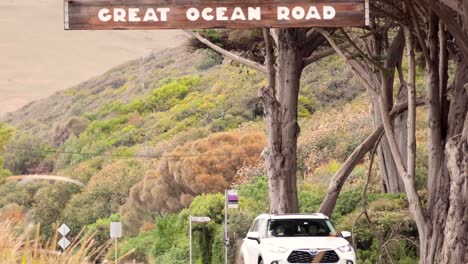 car driving under great ocean road sign