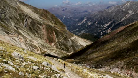 un ciclista que lucha por subir la montaña mientras se acerca una moto para un maratón de bicicleta de montaña en tzoumerka en grecia
