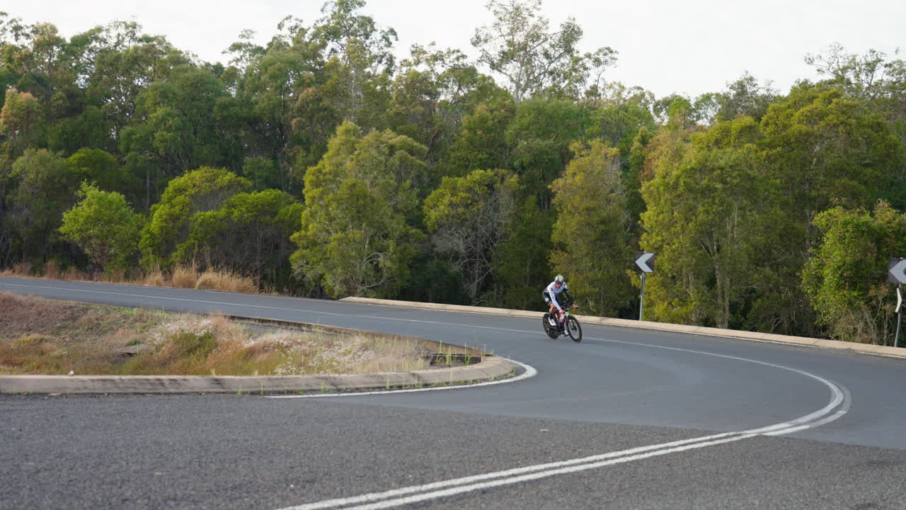 ciclista montando bicicleta, inclinándose en la esquina de un camino sinuoso, 4k