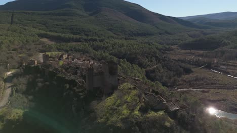 Drohne-Umkreist-Die-Mittelalterliche-Burg-Des-Verlassenen-Dorfes-Ruesta,-Spanien