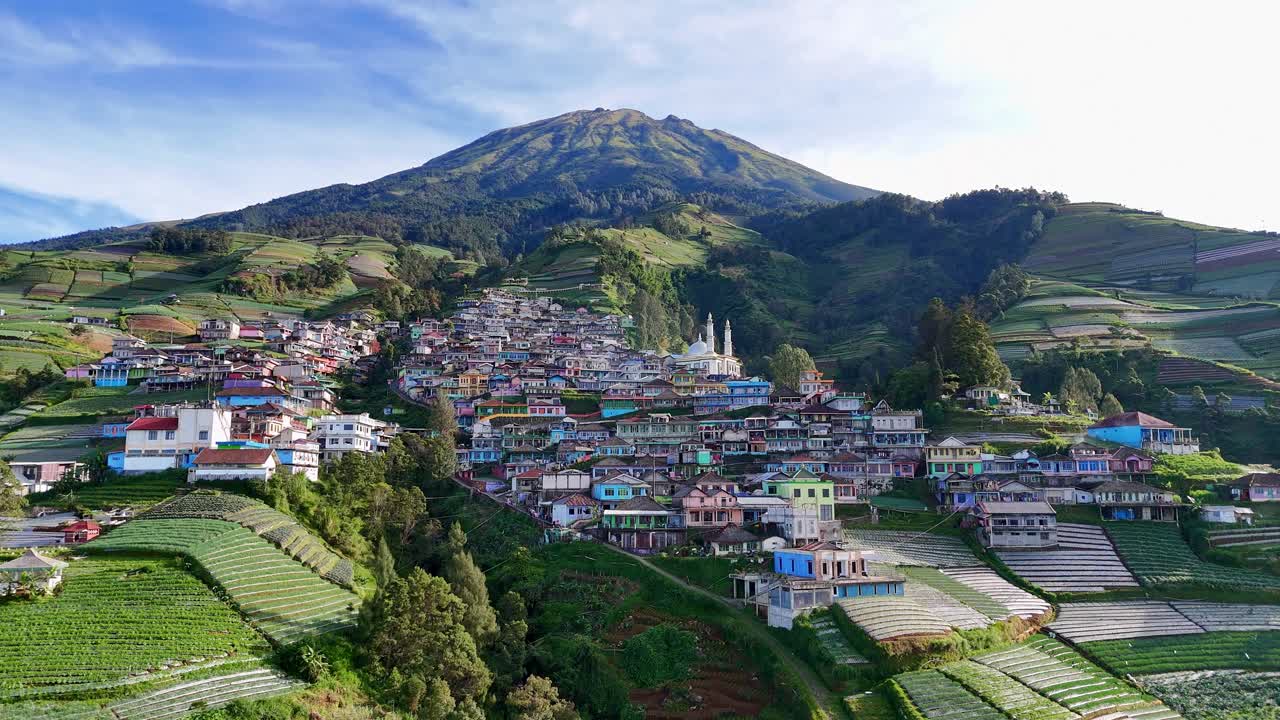 Aerial captivating highland view, showing a densely built village on a green mountain slope. Nepal Van Java village, Mount Sumbing, Indonesia