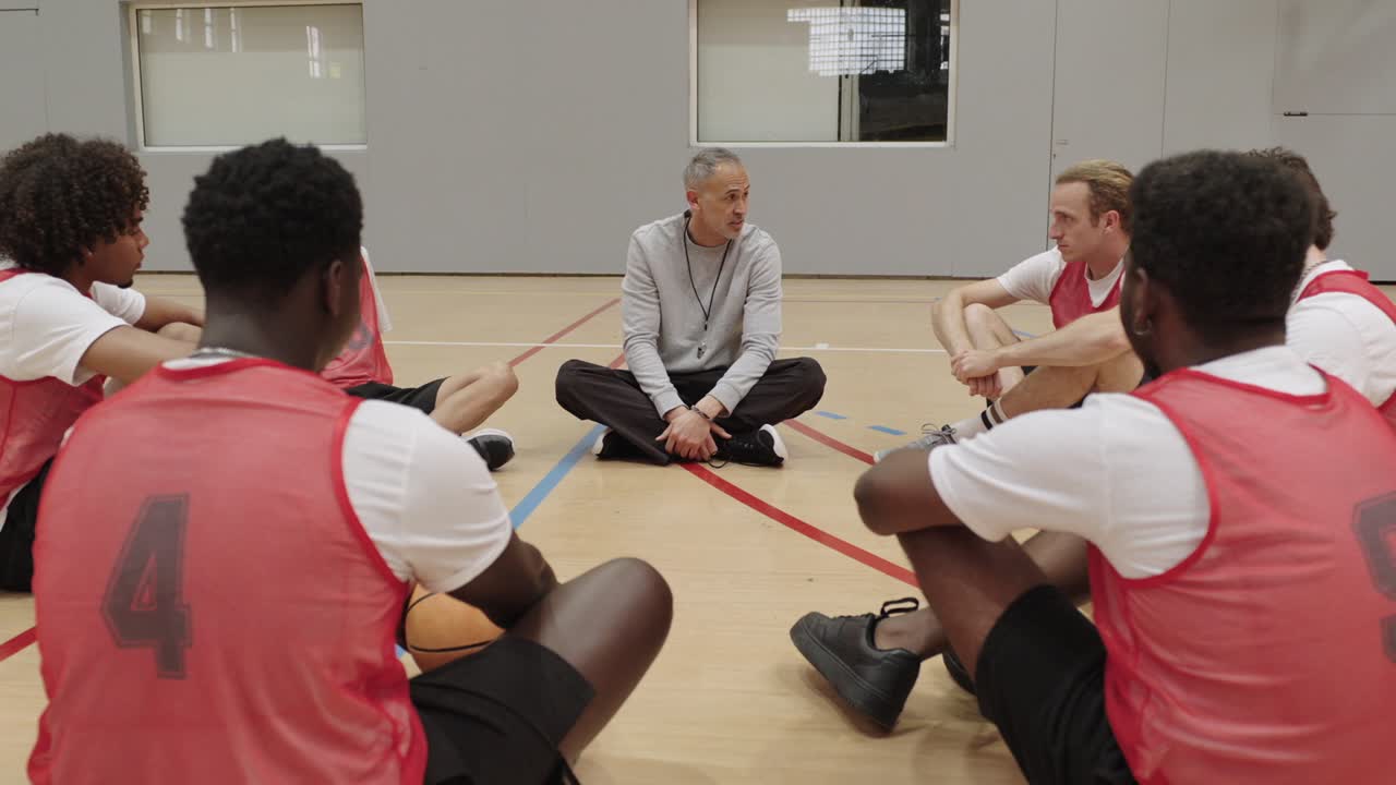Basketball team huddling with coach