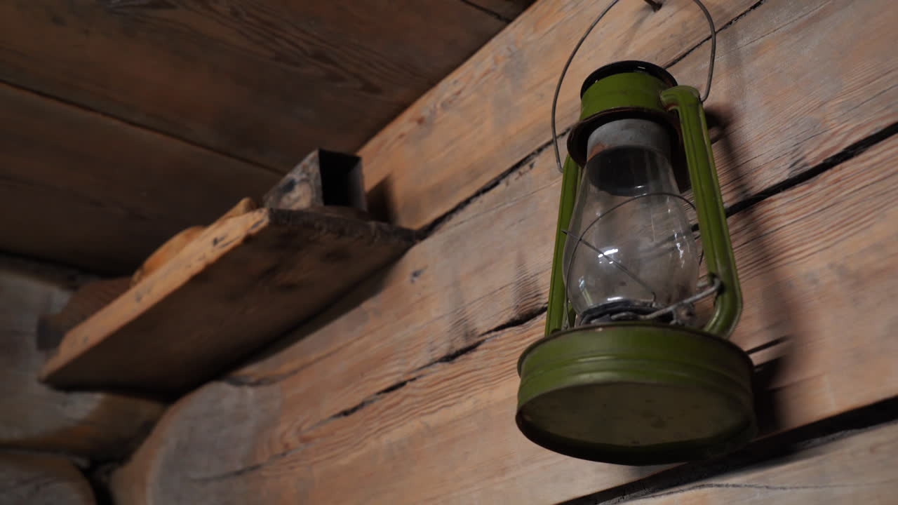 Antique Green Oil Lamp Hanging on Wooden Wall