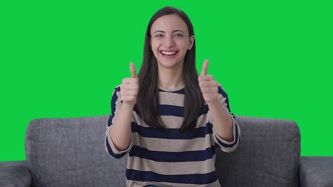chica india feliz haciendo pulgares hacia arriba pantalla verde