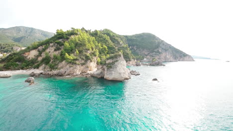 FPV-Drone-flying-over-turquoise-waters-towards-land-in-Greece