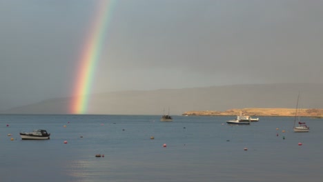 una foto lenta de un doble arco iris vibrante sobre el puerto de tobermory