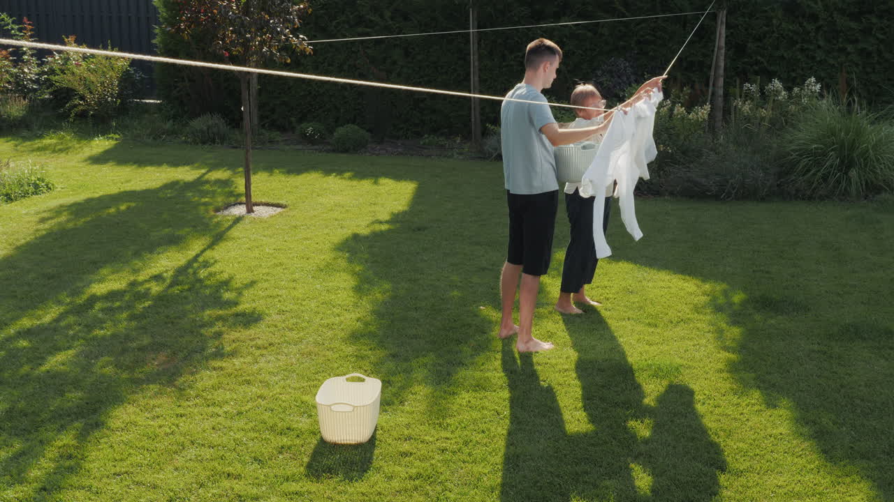 Teenagers Hanging Clothes Outside