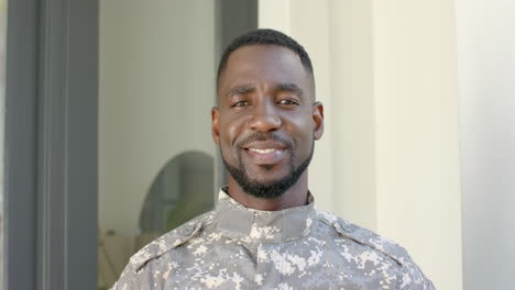 african american soldier in military uniform smiles warmly at home