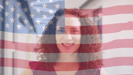 Animation-of-flag-of-america-blowing-over-smiling-biracial-female-teacher-in-school-corridor