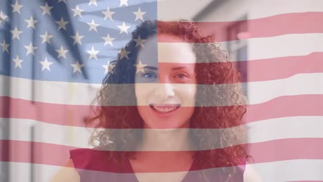animation of flag of america blowing over smiling biracial female teacher in school corridor