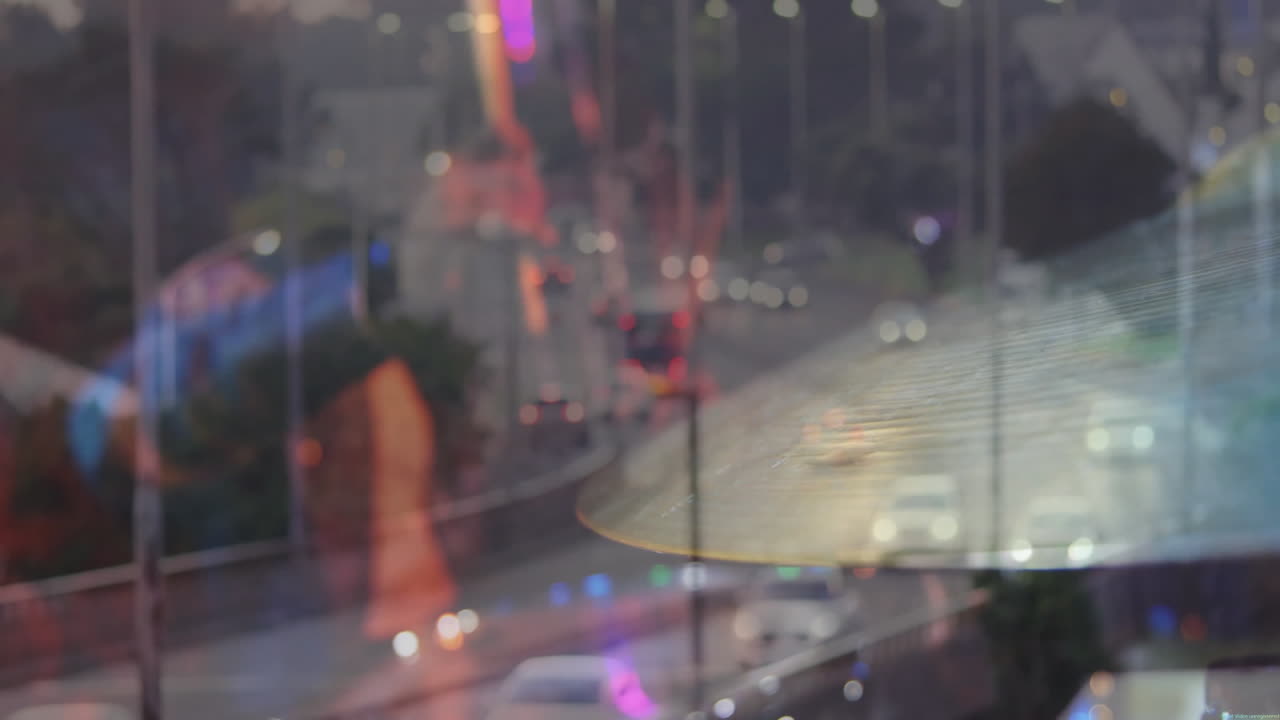 man wearing eyeglasses watching urban highway, with floating data icons mapping transportation flow