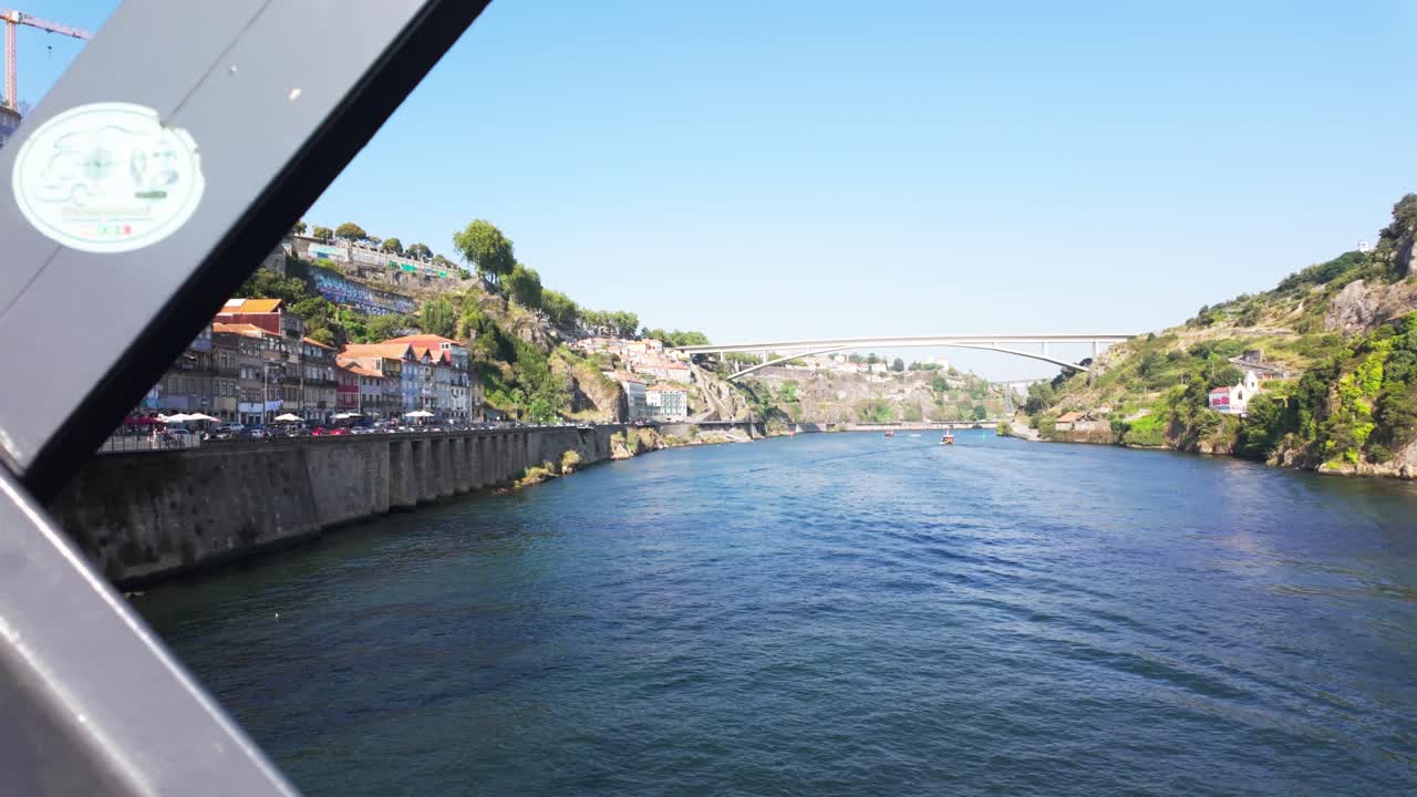 Tourists walking across the Luís I Bridge in Porto on a sunny day, capturing a vibrant urban scene