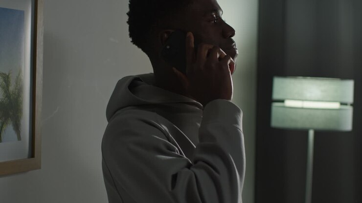 Jeune homme chez lui, parlant au téléphone portable, réagissant et ayant l'air contrarié après avoir reçu de mauvaises nouvelles 4.