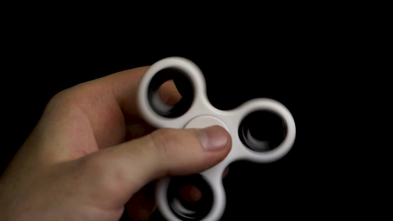 Person holding a white fidget spinner