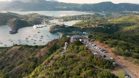 sunny aerial shot of english harbor in antigua, caribbean with views of yachts, sailboats, marina, bay and cliffs