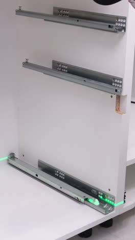 a man using a laser level to install a drawer in a kitchen cabinet apartment renovation concept