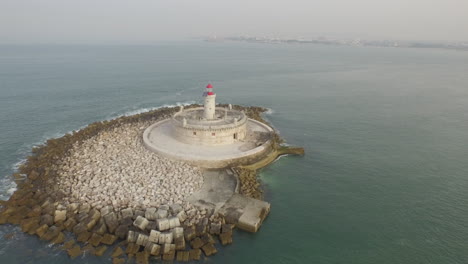 amazing lighthouse in the middle of the ocean with view of lisbon in the horizon