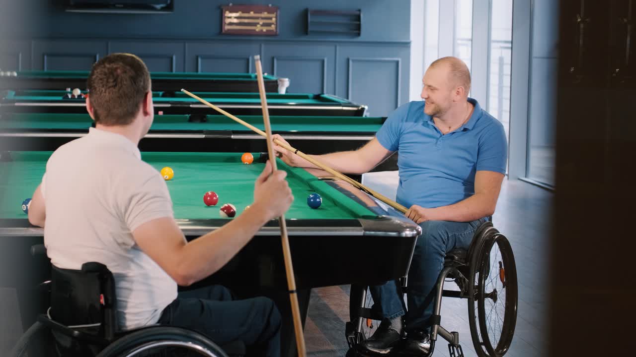 hombres adultos con discapacidad en silla de ruedas juegan al billar en el club