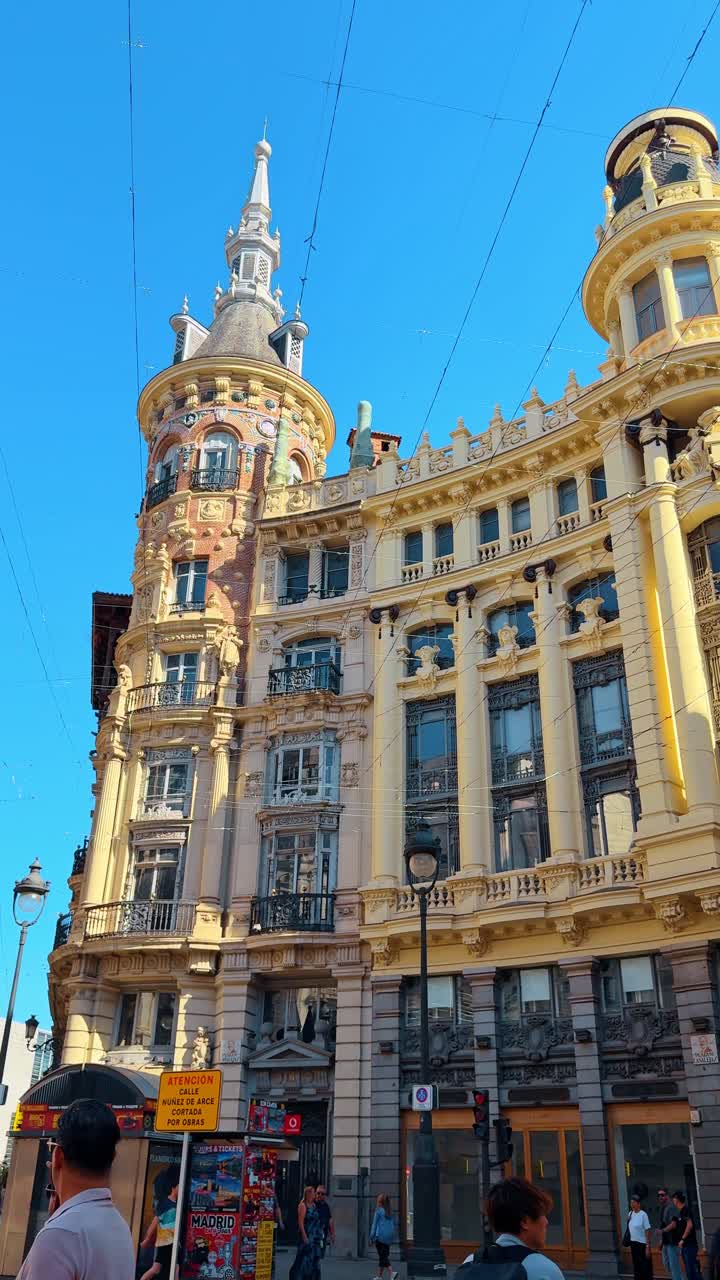 Madrid, Espanja, 2. elokuuta 2025: Historiallinen koristeellinen rakennuksen julkisivu kadulla Madridissa. Ulkokuva keltaisesta historiallisesta rakennuksesta, jossa on koristeellinen torni ja parvekkeet, aurinkoisena päivänä Espanjassa.