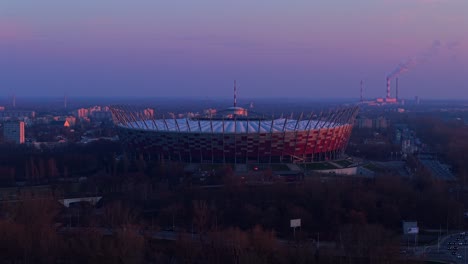 aerial shot of warsaw's pge narodowy stadium with sunset over coal plant and city
