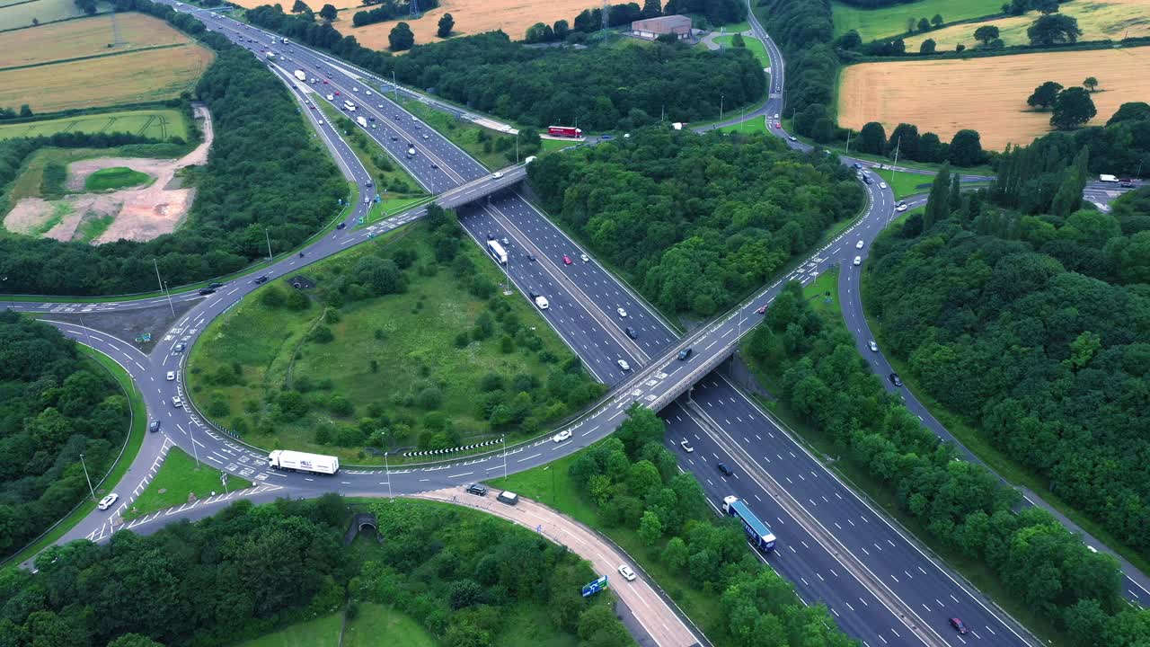 Sold static aerial view of a busy motorway junction with cars and trucks travelling along.