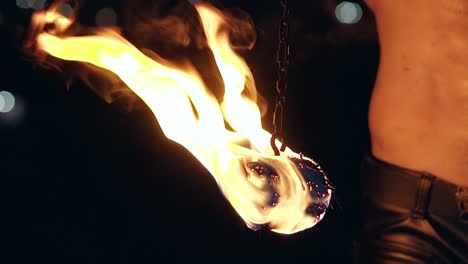 Close-up-slow-motion-shot-of-burning-poi-hanging-on-chain