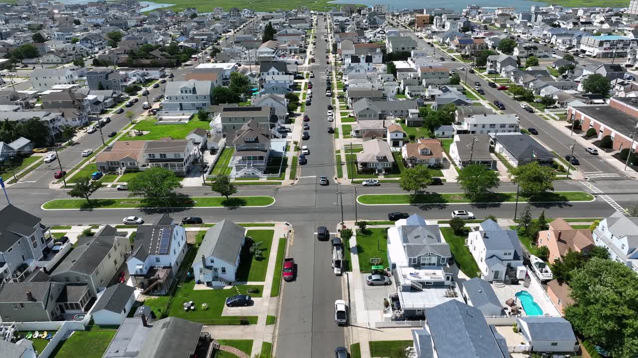 Wildwood, new Jersey. Luxury beach houses, tree-lined roads, Atlantic Ocean and classic American coastal town symmetry under blue summer sky. Aerial wide shot. Sunny day in summer