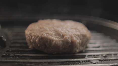 Rindfleisch--Oder-Hähnchenburger-Auf-Dem-Grill,-Der-Für-Ein-Köstliches-Hamburger-Sandwich-Zubereitet-Wird,-Mit-Schwarzem-Hintergrund-Und-Einfachem-Lichtaufbau,-Aufgenommen-Auf-Rohem-4k