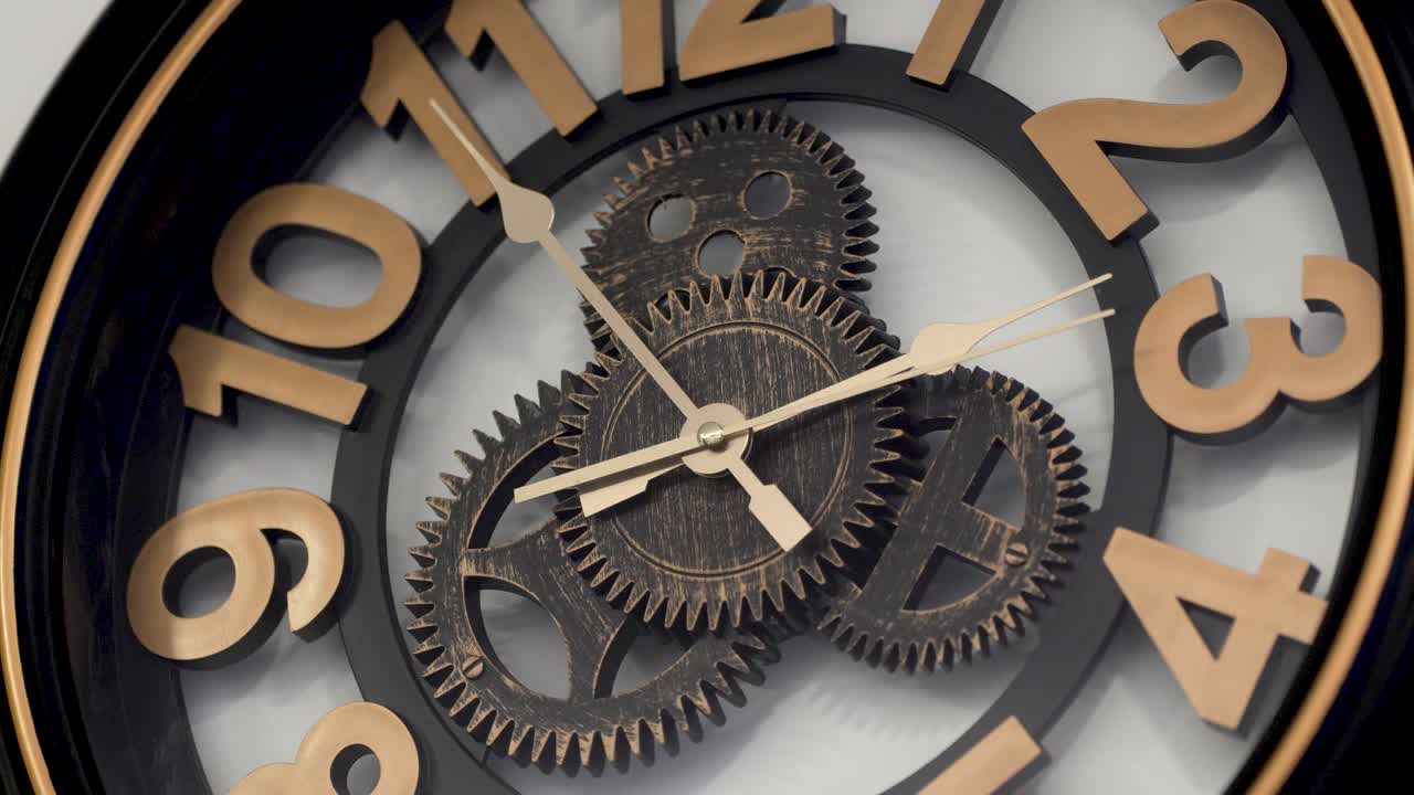 Cropped vintage design wooden wall clock with open mechanism shows ten to two, second hand is running and moving clockwise
