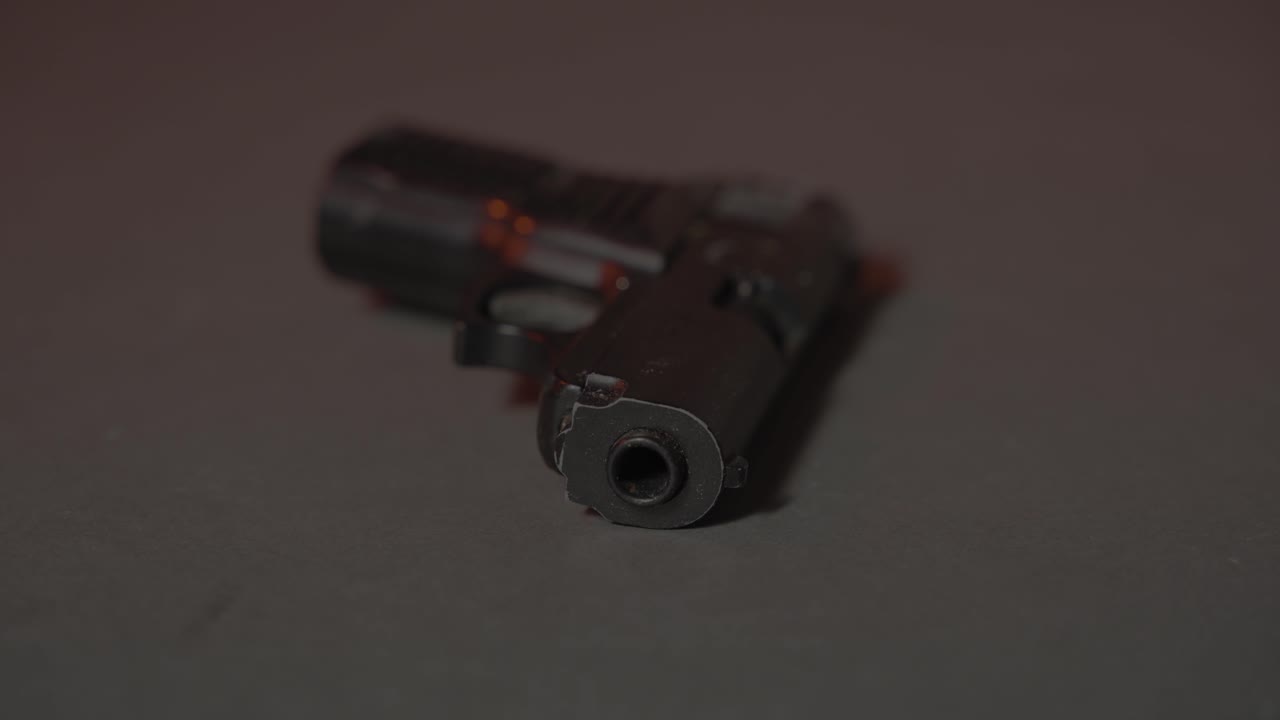 Gun on Ground Lit by Police Lights