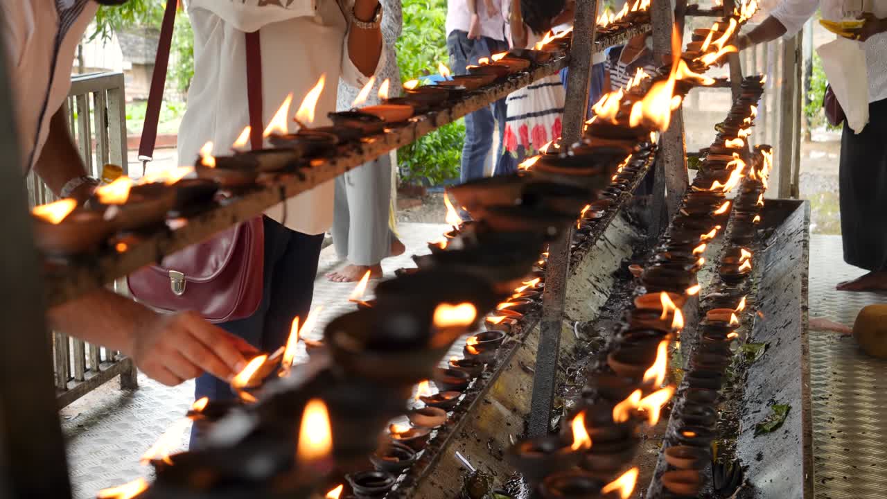 불교 사원에서 불타는 기름 램프를 불태우고 제단에 놓는 불교 신자들의 4k 비디오