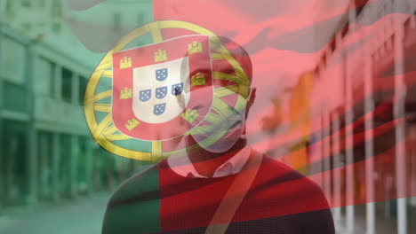 animation of flag of portugal waving over african american man wearing face mask in city street