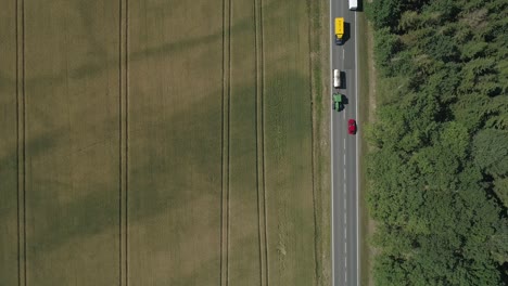 Intriguing-top-down-look-at-commuters-on-a-road-between-fields-and-forest