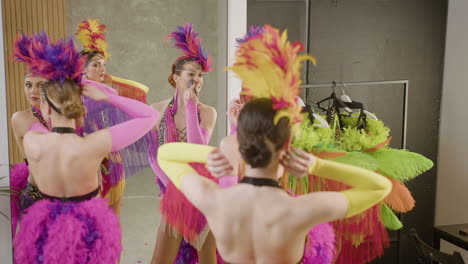 three showgirls getting ready and applying makeup