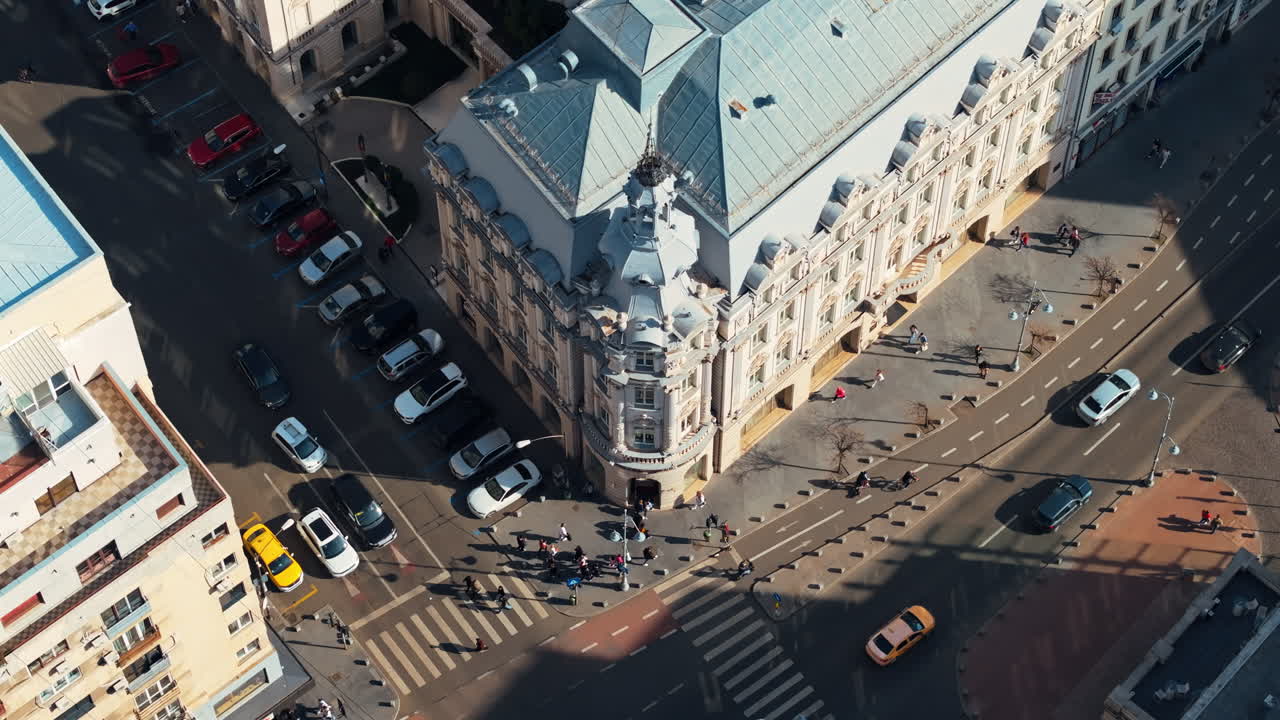 Aerial drone top view of a downtown old historical building in the sunlight. Moving traffic in Bucharest, Romania