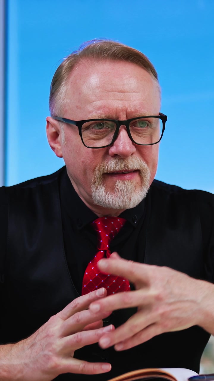 Fokuseret kaukasisk mand sidder ved skrivebordet, kigger til siden og nikker. Chefen lytter til sine medarbejdere og nikker anerkendende. Vertikal video