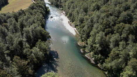 High-Fly-over-drone-footage-overlooking-river-running-through-forest-at-Murchinson,-New-Zealand