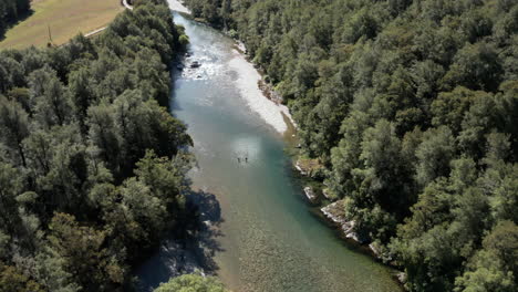 high fly over drone footage overlooking river running through forest at murchinson, new zealand