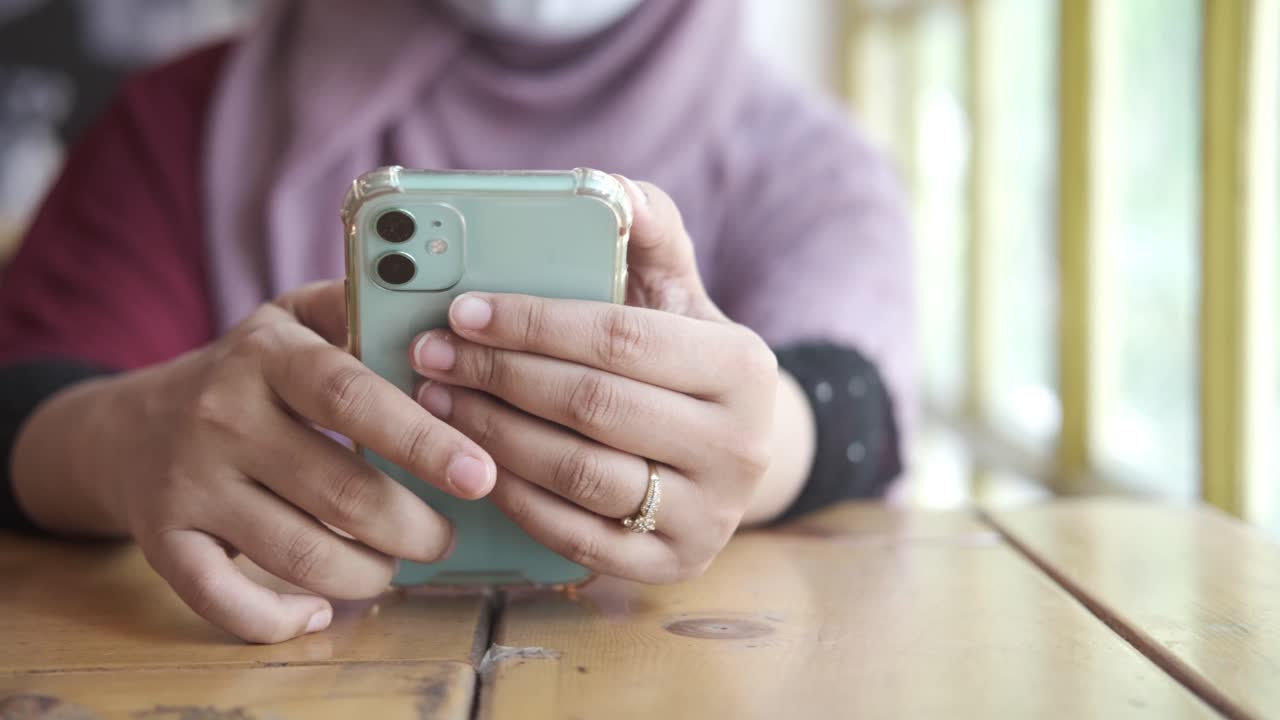 mujer usando un teléfono inteligente en un café
