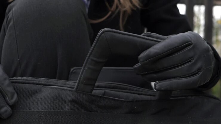 Donna d'affari con valigetta e guanti, primo piano