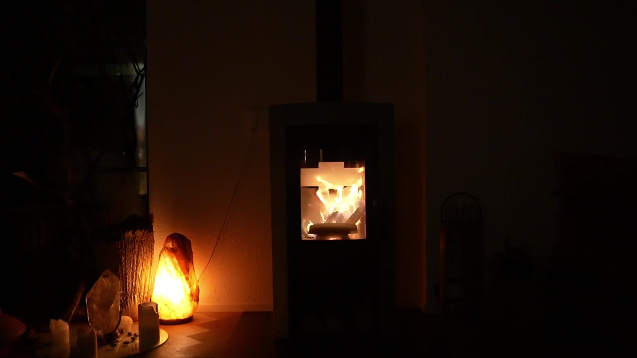 A dimly lit room bathed in the warm glow of a crackling fireplace. Flickering flames cast dancing shadows on the walls, creating a mesmerizing ambiance. A nearby salt lamp casts a soft, ethereal light