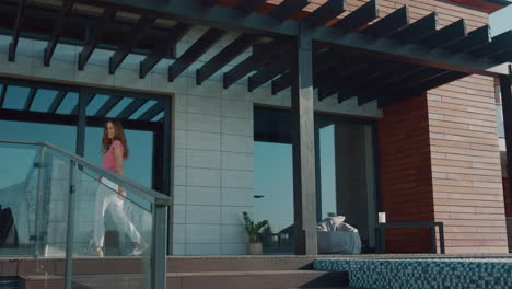 beautiful woman invite luxury house. brunette woman call to enter house