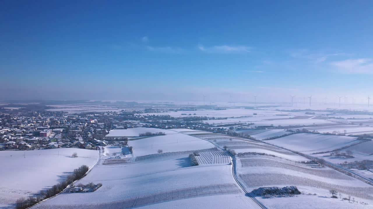 오스트리아 남부 지스터스도르프의 겨울철 풍력 발전 단지 근처의 설원과 지역사회