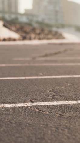 close-up of asphalt road with white lines near beach and city buildings