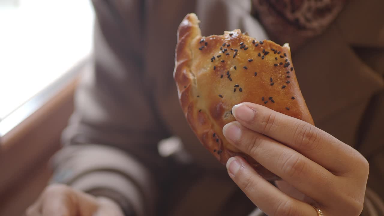 Close-up of a Person Eating a Savory Pastry