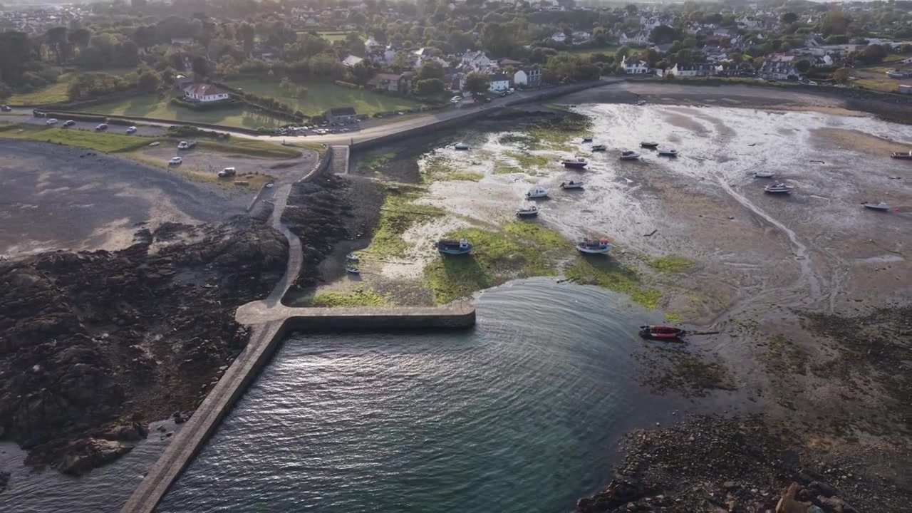 Porto di Bordeaux, Guernsey, Isole del Canale. Vista del porto con barche che si asciugano con la bassa marea, che si estende fino a panorami su tutta l'isola sotto il sole del tardo pomeriggio