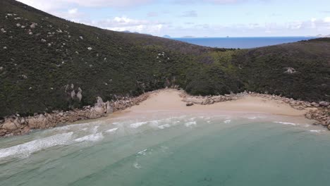 Dron-Aéreo-Gira-Lentamente-Sobre-El-Hermoso-Agua-Azul-Claro-Y-La-Montaña-Verde-En-Un-Día-Soleado-En-El-Promontorio-De-Wilson