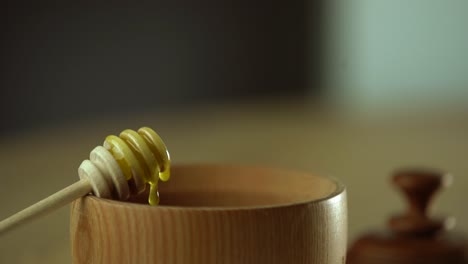 thick honey dripping from the spoon, close up. honey flowing honey from a spoon