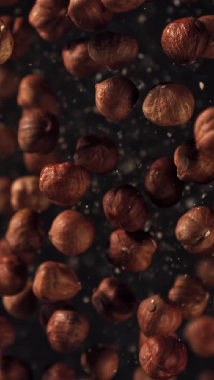 Nocciole che cadono in super rallentatore con particelle fini