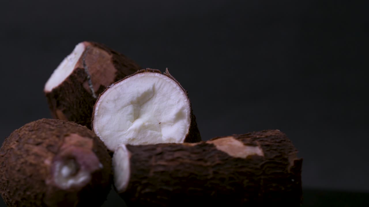 4K rotating close-up of sliced cassava root (tapioca, yuca, manioc). This tropical tuber highlights global cuisine, organic farming, gluten-free diets, superfoods, and farm-to-table nutrition